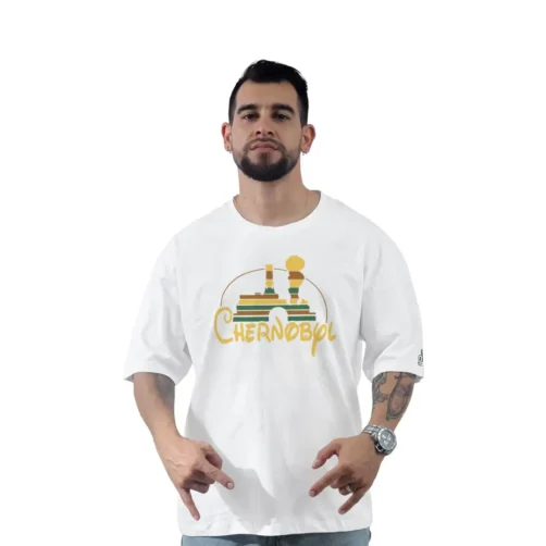 Hombre con una camiseta blanca con un gráfico de Chernóbil, de pie sobre un fondo liso. El diseño presenta líneas atrevidas y colores vibrantes que recuerdan a los estilos de anime, lo que le agrega un toque cultural intrigante a las imágenes icónicas.