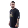 Un hombre barbudo con una camiseta Oversized de Chernobil / Disney, que fusiona estilos retro con vibraciones de la cultura pop, mira por encima del hombro y su reloj capta la luz.