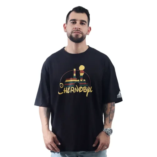 Un individuo con barba que viste Chernobil / Disney - Camiseta Oversized fusiona sin esfuerzo elementos de estilos de anime en una apariencia moderna mientras se encuentra de pie sobre un fondo blanco liso.
