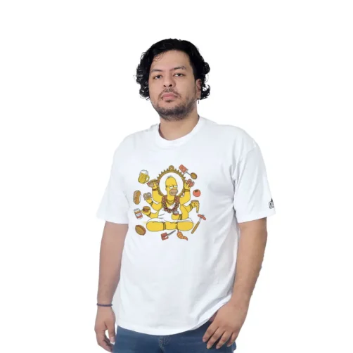 Una persona que viste una camiseta blanca con un diseño de dibujos animados se encuentra sobre un fondo blanco liso, representando el estilo cultural pop con sus ilustraciones extravagantes y vibrantes.