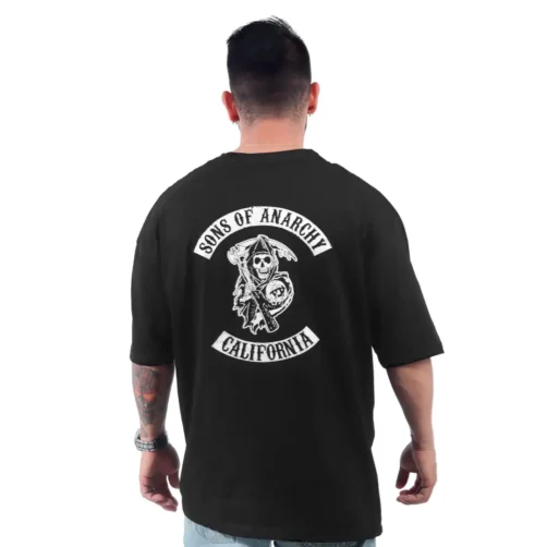 Un hombre viste una camiseta negra de "Sons of Anarchy California" con el icónico logo en la espalda, capturando estilos de cultura pop sin esfuerzo.