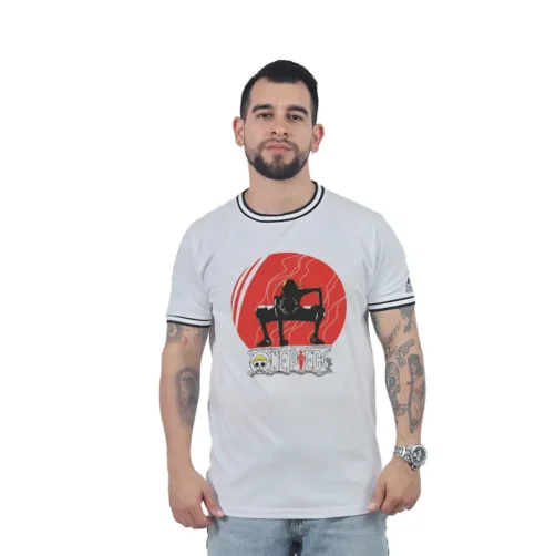 Un hombre que viste una camiseta blanca con un gráfico y texto en rojo se encuentra sobre un fondo blanco, mostrando su estilo de jugador único.