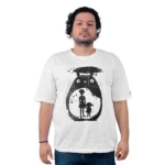 Una persona que viste una camiseta blanca con un diseño de silueta negra de una criatura grande, que envuelve a dos personas dentro de su contorno, refleja Estilos de anime con su composición llamativa y dinámica.