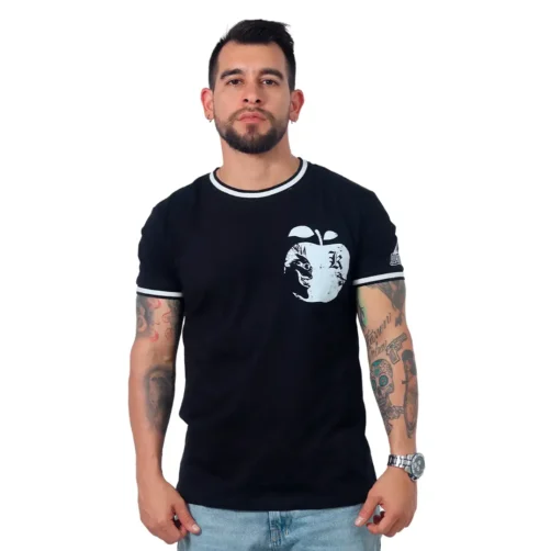 Un hombre con tatuajes y barba exhibe una camiseta personalizada: una camiseta negra que presenta un diseño gráfico de manzana.