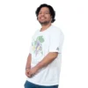 Una persona que viste una camiseta blanca con un diseño colorido inspirado en el anime, sonriendo sobre un fondo blanco liso.