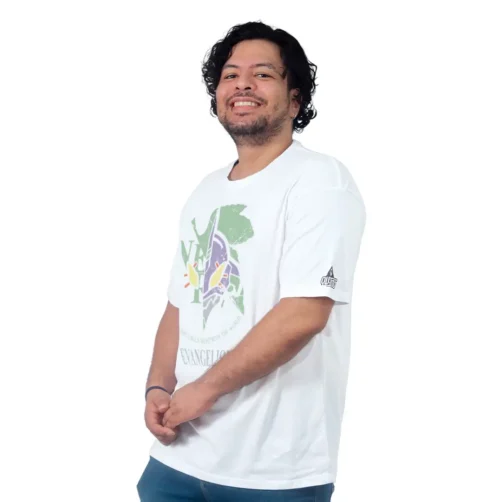 Una persona que viste una camiseta blanca con un diseño colorido inspirado en el anime, sonriendo sobre un fondo blanco liso.
