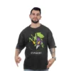 Un hombre que viste una camiseta negra de Evangelion, con un diseño gráfico atrevido que recuerda a los estilos retro, apunta hacia abajo con ambas manos.