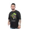 Un hombre con tatuajes posa vistiendo la Eva 01 - Camiseta Oversized, que muestra gráficos vibrantes que capturan perfectamente los estilos de anime y celebran los estilos de la cultura pop.