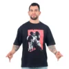 Un hombre vestido con el Cazador de Recompensas Star Wars - Camiseta Oversized, haciendo una pose con los dedos apuntando hacia abajo, encarna estilos de cultura pop al canalizar vibraciones icónicas mandalorianas a través de su atuendo.