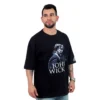 Un hombre viste una camiseta "John Wick - Oversized" en color negro, capturando la esencia de los estilos culturales pop con estilo.