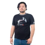 Una persona con cabello rizado lleva puesta la camiseta negra "Nave Red Leader - Camiseta Cuello Tejido", con un diseño de temática espacial que combina estilos de cultura pop. Está de pie sobre un fondo blanco liso.