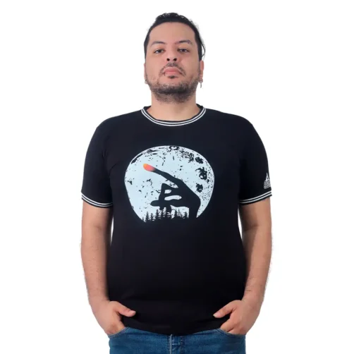 Una persona con un pendiente, vestida con un "Dedo E.T. - Camiseta Cuello Tejido" negro y pantalones vaqueros, se encuentra sobre un fondo blanco liso, canalizando sin esfuerzo los estilos retro.