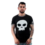 Un hombre con tatuajes viste la camiseta Sid Toy Story - Camiseta Cuello Tejido, una camiseta negra personalizada que presenta un diseño de calavera blanca, sobre un fondo liso.