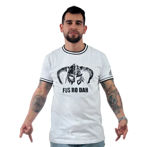 Un hombre se para con confianza, gesticulando hacia abajo, con una "Fus Ro Dah de Skrim - Camiseta Cuello Tejido" blanca de estilo retro, que presenta un gráfico de un casco y el texto "FUS RO DAH".