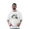 Un hombre que lleva una camiseta blanca personalizable con un gráfico con el tema del Monopoly que dice "Sal de la cárcel gratis" encarna el estilo cultural pop. Está haciendo una pose con las manos formando un gesto expresivo, combinando sin esfuerzo el estilo moderno con la nostalgia de los juegos de mesa clásicos.