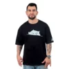 Un hombre con tatuajes viste la "Meme de Gatita - Camiseta Oversized", una camiseta negra adornada con un lindo gráfico de gato, que captura la esencia de los estilos culturales pop.