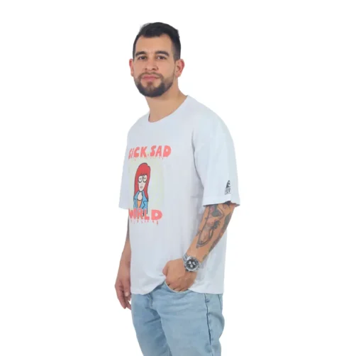 Una persona con barba se encuentra en Sick Sad Reality - Camiseta Oversized, una camiseta gráfica blanca de gran tamaño que presenta una ilustración inspirada en estilos de cultura pop, combinada con jeans azules, mirando a la cámara.