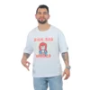 Un hombre que viste una camiseta blanca que dice "Sick Sad Reality - Camiseta Oversized" con un personaje de dibujos animados de Estilos de anime la combina con jeans azul claro, de pie sobre un fondo blanco.