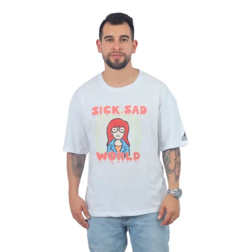 Una persona que viste la camiseta "Sick Sad Reality - Camiseta Oversized", una camiseta blanca con un personaje de dibujos animados y el texto "Sick, Sad World" con estilo retro, se encuentra sobre un fondo liso.
