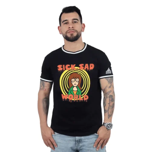 Un hombre que viste la camiseta "Sick Sad World - Camiseta Cuello Tejido", que muestra un diseño de personaje de dibujos animados, se para con confianza sobre un fondo sencillo, capturando la esencia de Estilos retro.