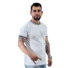 Un hombre con barba y tatuajes viste el USS Enterprise (NCC-1701) - Camiseta Cuello Tejido junto con unos jeans, haciendo un gesto con la mano sobre un fondo blanco liso, exudando la confianza fría que a menudo se ve en los estilos gamer.