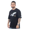 Un hombre viste la camiseta de gran tamaño USS Enterprise (NCC-1701), que presenta un gráfico de nave espacial y captura la esencia de la serie Estilos.